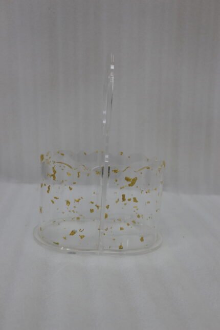 Clear acrylic spoon holder featuring decorative gold flake accents, a convenient top loop carry handle, and organized stainless steel spoons on a kitchen countertop.
