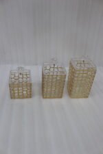 A luxury 3-piece clear acrylic jar set with gold geometric patterns and crystal lids, neatly arranged on a white marble kitchen countertop.