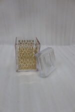 Set of three clear acrylic kitchen storage jars with elegant gold patterned designs, displayed on a marble countertop.