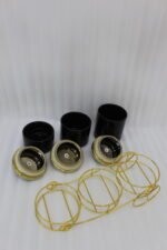 Luxury 3-piece black and gold ceramic storage jar set with golden lids arranged on an elegant gold metal cart stand on a modern kitchen countertop.