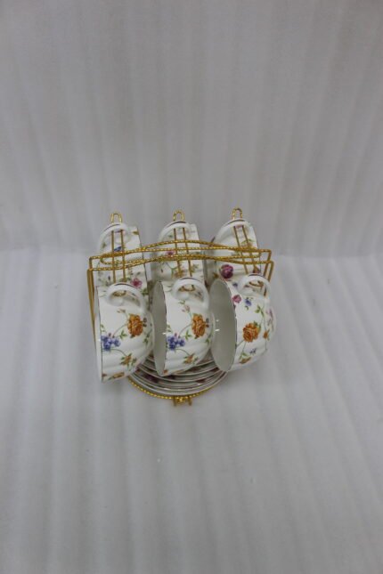Luxury ceramic tea set with 6 floral cups, matching saucers, and a golden stand on a kitchen counter.