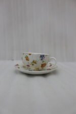 Luxury ceramic tea set with 6 floral cups, matching saucers, and a golden stand on a kitchen counter.