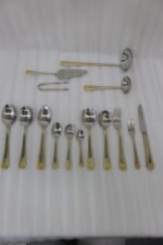72-piece stainless steel cutlery set with gold trim handles and specialty serving utensils displayed on a white tray.