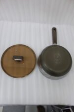 A collection of high-quality titanium stainless steel woks and frying pans in sizes 24cm, 26cm, 28cm, and 30cm with glass lids and ergonomic handles displayed on a kitchen counter.