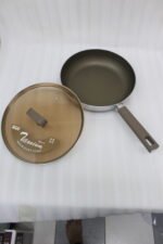 Three sizes of premium non-stick titanium fry pans with matching glass lids and brown ergonomic handles displayed on a granite countertop.