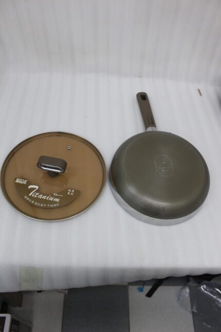 Three sizes of premium non-stick titanium fry pans with matching glass lids and brown ergonomic handles displayed on a granite countertop.