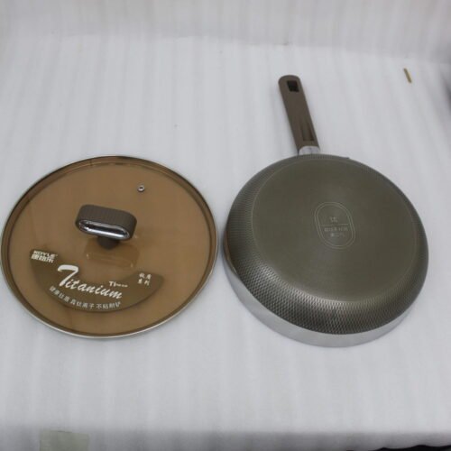Three sizes of premium non-stick titanium fry pans with matching glass lids and brown ergonomic handles displayed on a granite countertop.
