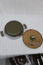 Four stainless steel double-handle woks with glass lids in 24cm, 26cm, 28cm, and 30cm sizes displayed on a dark kitchen countertop.