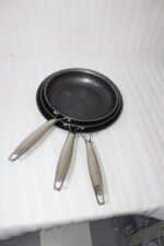 A 3-piece stainless steel cookware set with glass lids featuring 24CM, 26CM, and 28CM sizes displayed neatly on a kitchen counter.