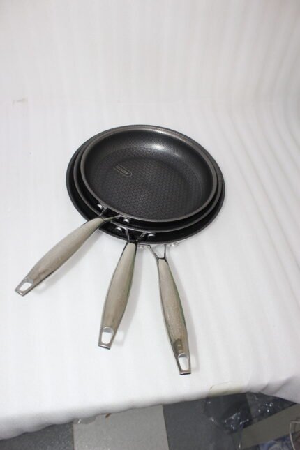 A 3-piece stainless steel cookware set with glass lids featuring 24CM, 26CM, and 28CM sizes displayed neatly on a kitchen counter.