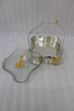 Three-piece silver hammered decorative bowl set with gold floral accents and overhead handles arranged on a wooden table.