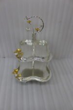 Two-tier silver hammered decorative serving tray with gold floral accents resting on a wooden coffee table in an elegant living room setting.