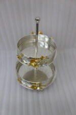 Two-tiered textured silver serving stand with gold floral accents displayed on a wooden table.