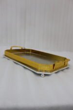 Set of two luxury gold and silver rectangular decorative serving trays with Greek key pattern borders resting on a white marble countertop.