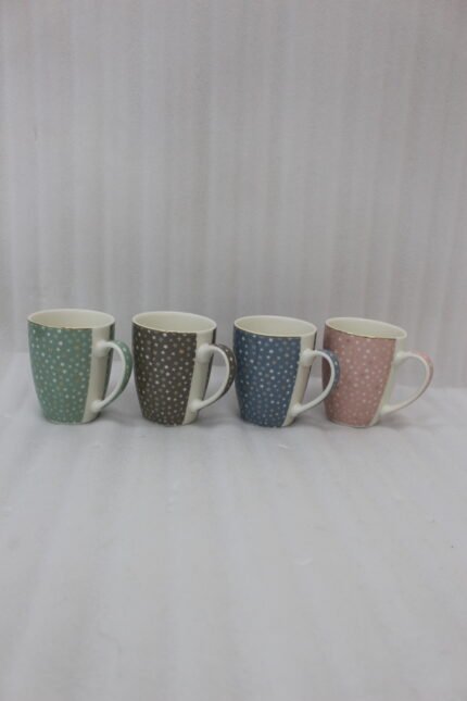 4-piece ceramic coffee mug set with gold star patterns in sage green, brown, navy blue, and blush pink on a white marble countertop.