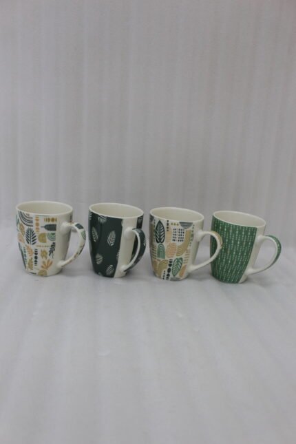 Four ceramic coffee cups featuring green, yellow, and beige geometric and botanical patterns lined up on a granite kitchen countertop