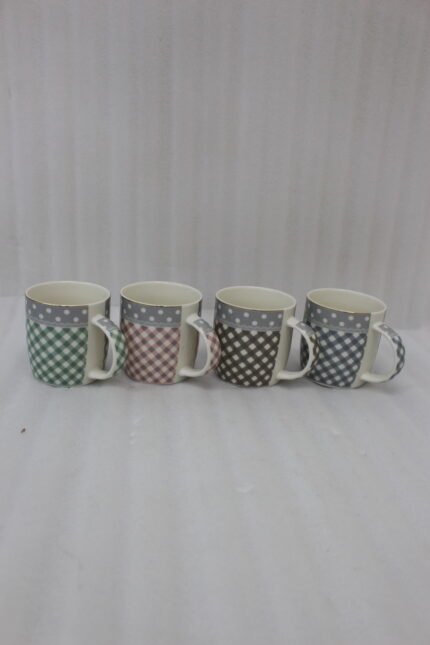 Four ceramic coffee mugs with gingham and polka dot patterns lined up on a marble countertop