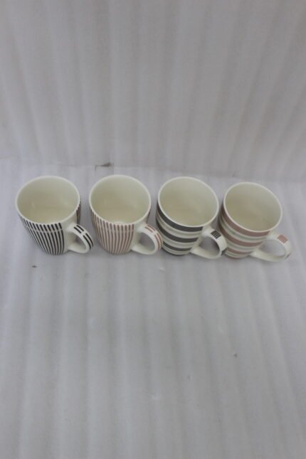 Four ceramic coffee cups with vertical and horizontal striped patterns lined up on a kitchen counter