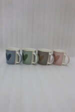 Four ceramic coffee mugs lined up on a kitchen counter in blue, green, brown, and pink with textured dot patterns and gold heart details.