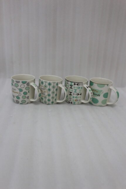 Four Onemore ceramic coffee mugs with teal and grey geometric patterns arranged on a wooden kitchen countertop.