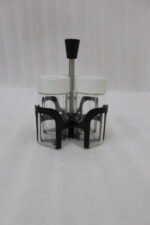 Four-piece clear glass spice jar set with lid options sitting in a black metal holder on a kitchen countertop.
