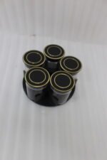 Four modern 6-piece revolving glass spice jar sets with gold trim lids displayed on a white kitchen countertop in beige, cream, black, and white colors.