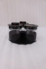 Four sets of ONE MORE 3-piece glass spice jars with trays sitting on a white marble countertop in beige, off-white, white, and black colors.