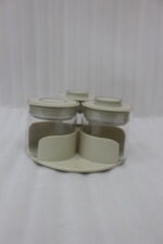 Four sets of ONE MORE 3-piece glass spice jars with trays sitting on a white marble countertop in beige, off-white, white, and black colors.