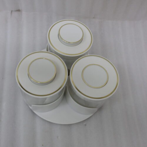 Four sets of ONE MORE 3-piece glass spice jars with trays sitting on a white marble countertop in beige, off-white, white, and black colors.