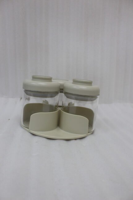 Four modern glass spice jar sets in black, tan, cream, and off-white with gold lid rings arranged on a marble kitchen countertop.