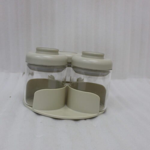 Four modern glass spice jar sets in black, tan, cream, and off-white with gold lid rings arranged on a marble kitchen countertop.