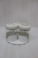 Four modern glass spice jar sets in black, tan, cream, and off-white with gold lid rings arranged on a marble kitchen countertop.