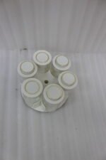Modern rotating spice rack organizer set with 6 clear glass jars and gold-accented lids on a granite kitchen countertop.