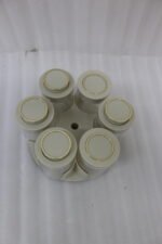 Modern rotating spice rack organizer set with 6 clear glass jars and gold-accented lids on a granite kitchen countertop.