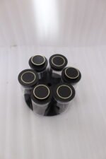 Modern rotating spice rack organizer set with 6 clear glass jars and gold-accented lids on a granite kitchen countertop.
