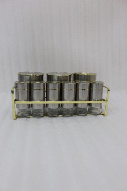 9-piece brushed stainless steel and glass spice jar set with gold rim accents arranged on a gold metal countertop rack