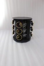Modern 12-piece rotating black and gold spice rack organizer with glass jars on a white marble kitchen countertop