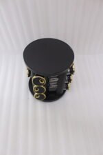 Modern 12-piece rotating black and gold spice rack organizer with glass jars on a white marble kitchen countertop