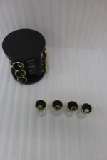 Modern 12-piece rotating black and gold spice rack organizer with glass jars on a white marble kitchen countertop