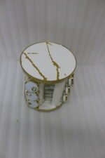 Modern 12-piece rotating black and gold spice rack organizer with glass jars on a white marble kitchen countertop