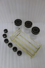 9-piece luxury glass spice jars with black gold-accented lids stored on a metallic gold wire rack on a marble kitchen countertop.
