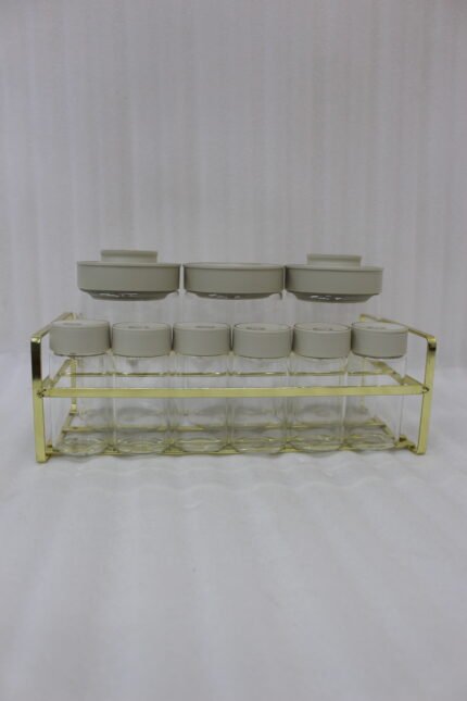 9-piece clear glass spice jar set with grey lids and a gold wire countertop rack