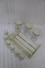 9-piece clear glass spice jar set with grey lids and a gold wire countertop rack