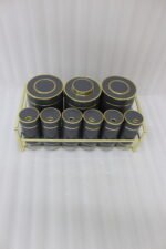 9-piece matte black and gold luxury spice rack set with clear glass bottoms on a granite countertop.