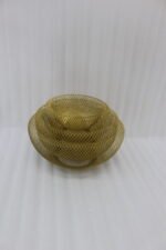 Set of three gold mesh decorative wire bowls sitting on a light wooden table in a brightly lit modern living room setup.
