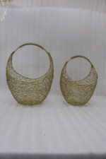 Add a touch of contemporary elegance to your interior with these handcrafted gold metal mesh baskets. Featuring an intricate, lacy wirework weave paired with a smooth rounded silhouette and a textured, coiled carry handle, these decorative baskets seamlessly balance functionality and aesthetic charm. Whether placed on a coffee table, console, or shelf, they work beautifully as standalone accents or stylish organizers for small accessories, fruit, or faux floral arrangements. Key Points Intricate Mesh Design: Features a unique, openwork woven metal texture in a luxurious warm gold finish. Ergonomic Handles: Designed with top curved handles wrapped in coiled wire detailing for an elevated look and comfortable grip. Versatile Accent: Ideal for living rooms, dining tables, entryways, or office desk organization. Set of Two Sizes: Comes in two complementary sizes for easy nesting, layered styling, or multi-room display. Durable Construction: Crafted from sturdy, high-quality metal to ensure long-lasting durability and style.
