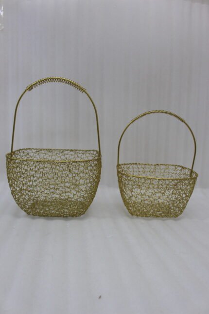 Two gold mesh metal decorative baskets with coiled top handles on a wooden table.