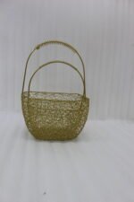 Two gold mesh metal decorative baskets with coiled top handles on a wooden table.