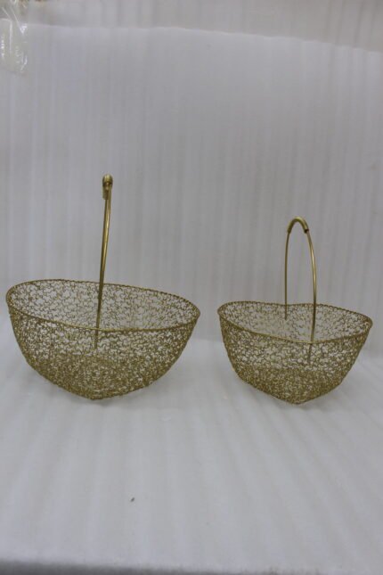Two heart-shaped decorative gold wire mesh baskets with single handles set on a wooden table.