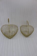 Two heart-shaped decorative gold wire mesh baskets with single handles set on a wooden table.